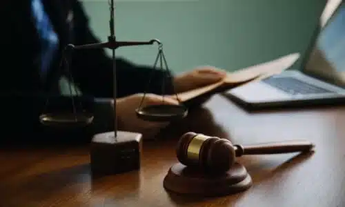 An uninsured motorist lawyer holding files at his desk while working on a case.