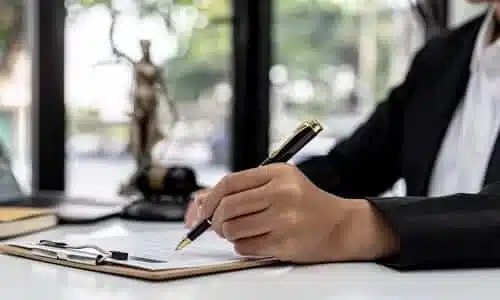 A chest-level shot of a personal injury lawyer in a ground floor office working on papaers.