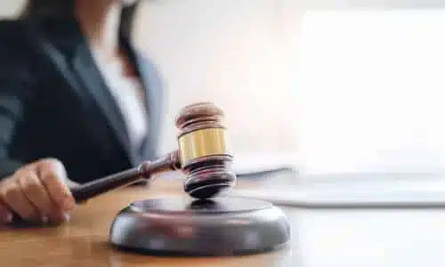 A lawyer brandishing her gavel over a soundblock while waiting in her office for a client.