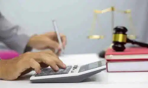 A workers' compensation lawyer calculating the total damages a client can get for his injury.