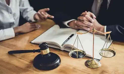 A wrongful death lawyer listening to a client tell him about the details of her case.