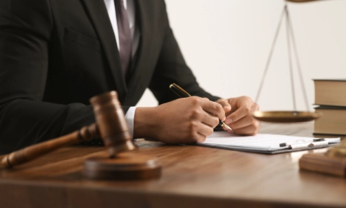 A personal injury lawyer sitting at a desk with law books, a gavel, and scales.
