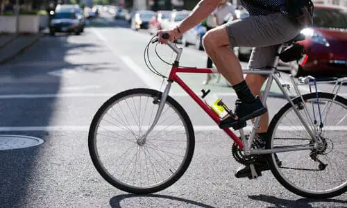 A cyclist crossing a road in the daytime.