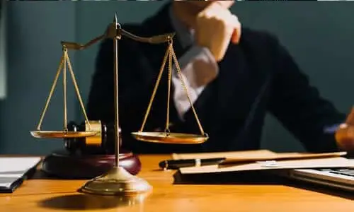 A defective product lawyer at a desk contemplating how to proceed with a case.