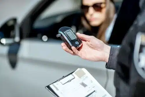 A police officer records the blood alcohol content of a drunk driver.