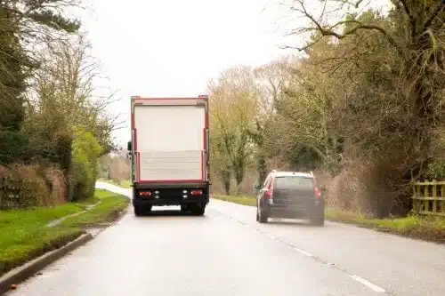 car speeding past a large truck