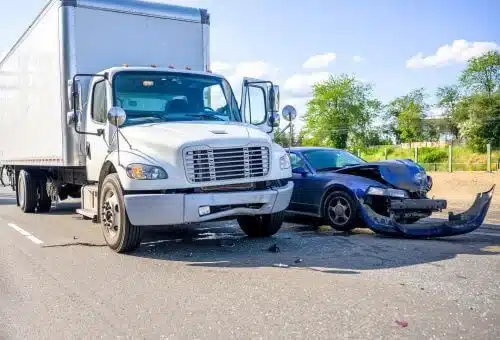A large white truck and a small white car are pictured after a an accident to the right side of the car in Fulton county.