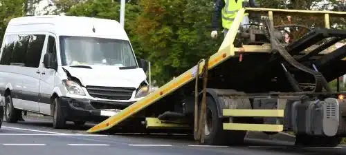 A company vehicle is loaded on a tow truck after an accident.