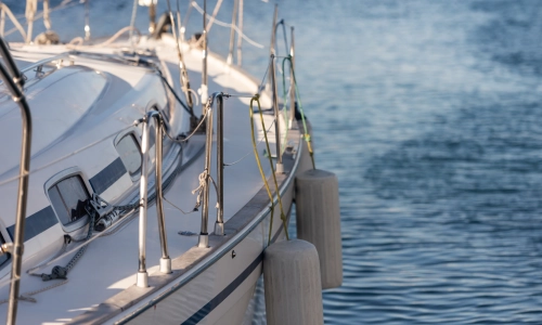 Close-up view of a boat docked at a marina, with ropes and bumpers securing it, representing a potential boat accident or maritime injury scenario.