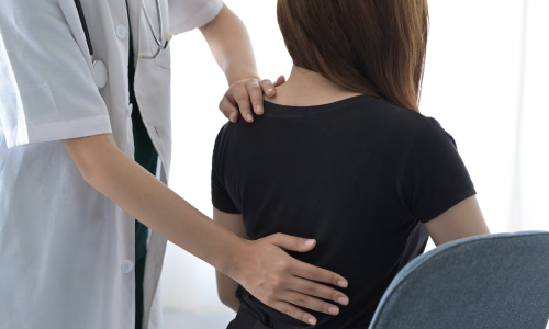 A doctor checking the injured back of a patient.