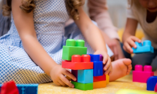 Daycare accident concept showing young children playing on the floor, highlighting a typical daycare environment where injuries could occur.