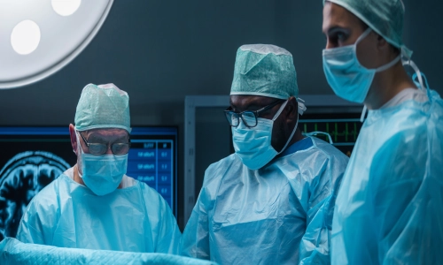  Three surgeons in an operating room wearing surgical masks and gowns, focusing intently during a procedure, representing a medical malpractice situation.
