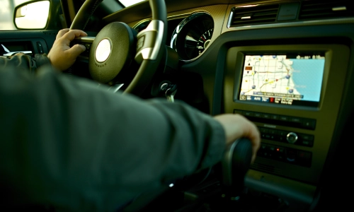 Driver operating a car with GPS navigation visible on the dashboard, representing a rideshare accident or ride-hailing service incident.