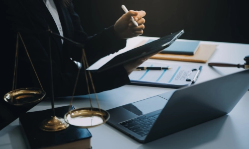 Lawyer reviewing documents at a desk with a legal contract, gavel, and scales of justice, representing legal work related to a truck accident.