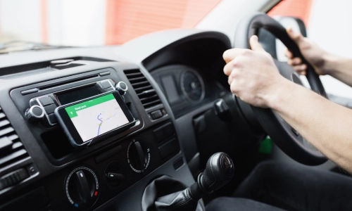  Driver operating a vehicle with a navigation app on a mounted smartphone, illustrating a typical rideshare driving setup and potential for a rideshare accident.