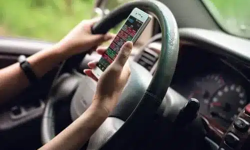 A distracted woman uses a cell phone while driving.