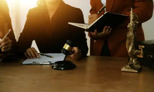 Lawyers reviewing contract documents with a gavel and Lady Justice statue on a desk, representing potential defective product injury