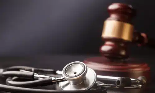 Stethoscope placed beside a judge’s gavel, representing the intersection of healthcare and law.