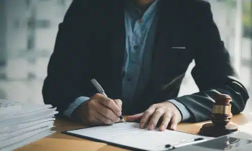 A lawyer reviewing legal documents at a desk with a gavel and paperwork, symbolizing legal services provided by an Augusta premises liability lawyer