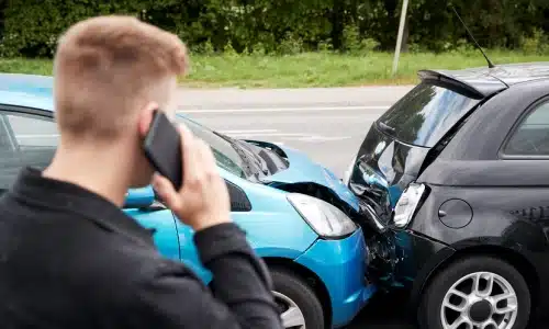 A rear-end accident between a rideshare vehicle and a black hatchback on the road.