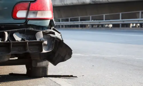 A car with a missing rear bumper after taking a collision from a hit and run driver.