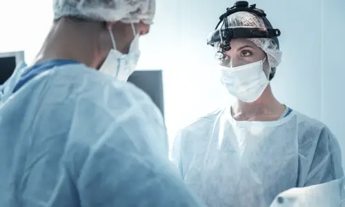 Doctors in an operating theater preparing for a patient's procedure.