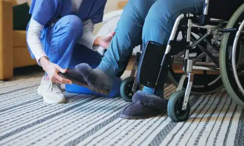 Caregiver assisting a person in a wheelchair, relevant to a Savannah nursing home abuse lawyer.