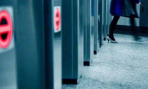 Person walking through a restricted turnstile area, symbolizing unsafe property access for a Savannah premises liability lawyer.