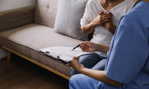 A nurse reviews a contract with a concerned elderly woman, symbolizing a consultation for a nursing home abuse lawyer.