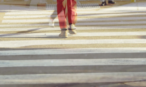 People walking across a sunlit crosswalk, symbolizing cases for a Columbus pedestrian accident lawyer.