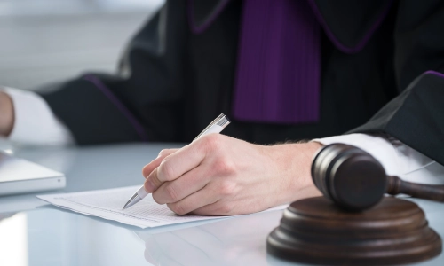 An Uber accident lawyer writing with their left hand while typing in a laptop that is out of view inside a Gainesville law office