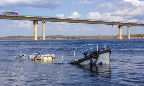 A sunken ship partially submerged in a river, connected to a recent boating accident that may require investigation by a Gainesville boat accident lawyer.