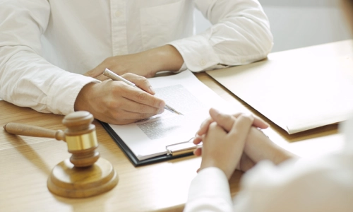 A slip and fall lawyer discussing a case with a client who is sitting on the other side of a table inside a Houston law office