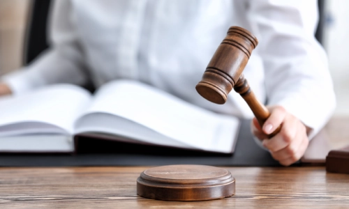 A distracted driving accident lawyer serving Houston clients is reviewing a law book, searching for the exact legal section needed to support his client’s case.