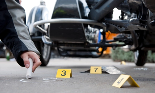 A lawyer who represents hit-and-run injury victims is carefully examining the accident scene to gather evidence that may support his client’s case.