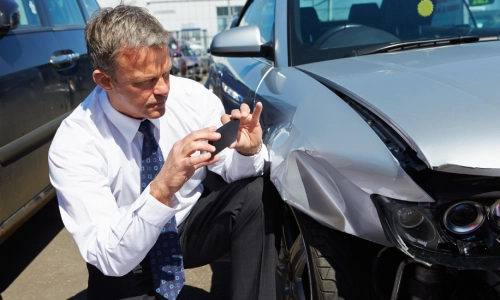 A California distracted driving accident lawyer taking photos of the accident scene where his client was involved.