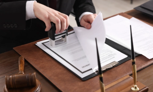 An Arizona car accident lawyer notarizing some documents on an office table
