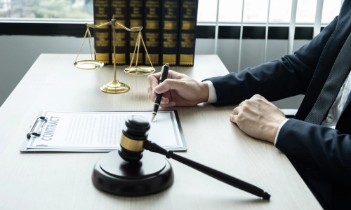 An Arizona Defective Product Lawyer sits inside a law office while notarizing documents on an office desk