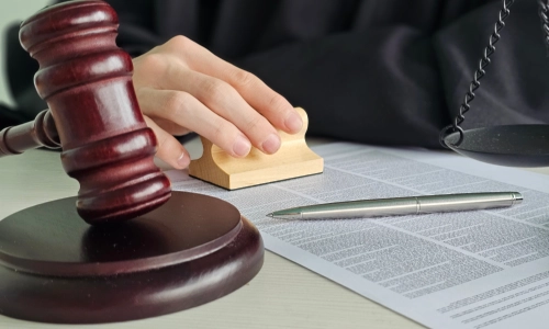 An Arizona hit and run lawyer with one hand on top of an open book while they sit inside a law office