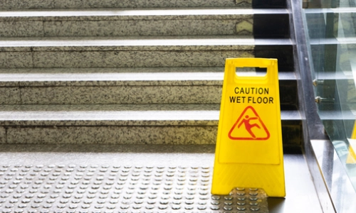 A photo of warning sign for wet floor near the stair.