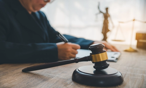 An Arizona wrongful death lawyer reviewing evidence-based case files and documents, with a gavel placed beside him.