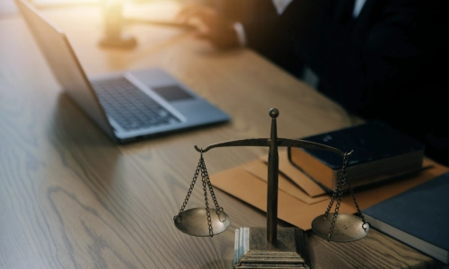 A motorcycle accident lawyer reading articles on their laptop placed on top of their work desk in a California law office