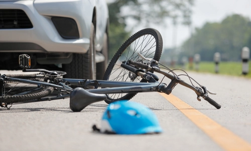 A damaged bicycle lay on the road after an accident.