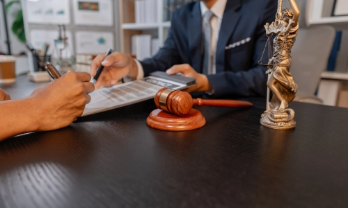 A Nogales rideshare accident lawyer discussing legal matters with a client in an office, providing legal advice and reviewing documents.