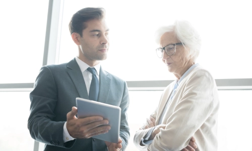 A Nogales nursing home abuse lawyer speaking with an elderly person about the nursing home abuse claim they are drafting.