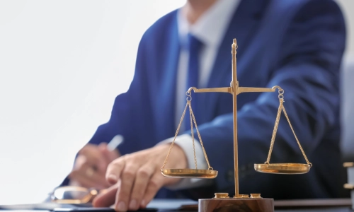 A Riverside Brain Injury Lawyer with his glasses laid on the table reading case files inside a law office.