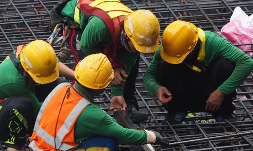 A scene of four construction workers wearing safety gear at a construction site in Riverside