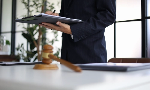 A daycare injury lawyer standing in a Riverside law office while reading through files on a black clipboard