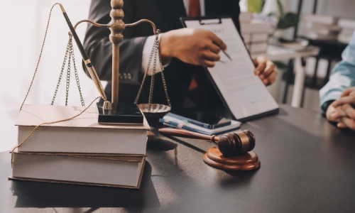 A drunk driving accident lawyer discussing a case to a client sitiing in front of them and showing the case files to the client while they sit in a Riverside law office