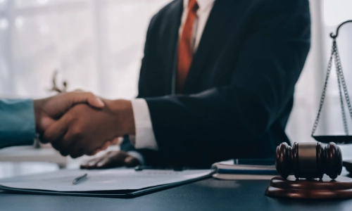 A Riverside Slip and Fall Lawyer is shaking the hand of a satisfied client while sitting inside a law office